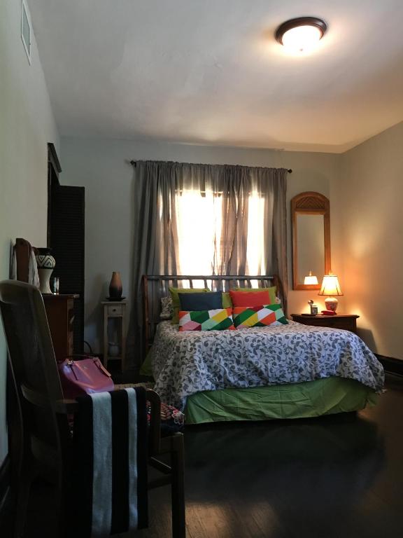 a bedroom with a bed with colorful pillows and a window at Private room in the Heart of Little Havana for 4 Guests in Miami