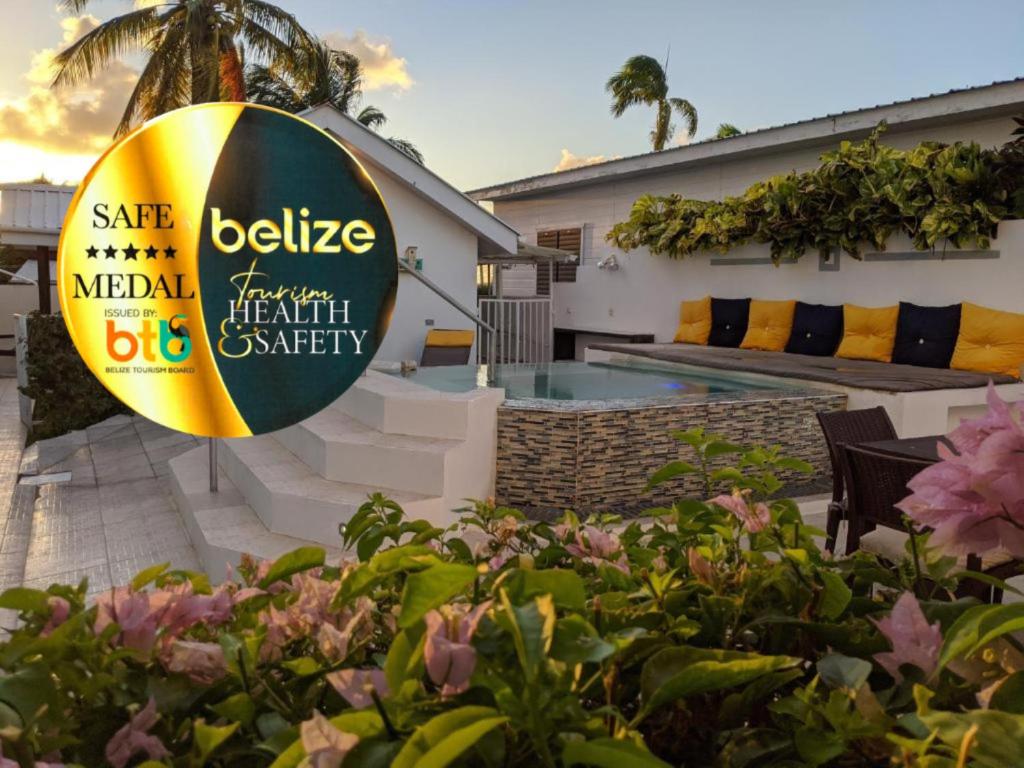 a sign in front of a house with a swimming pool at Villa Boscardi in Belize City