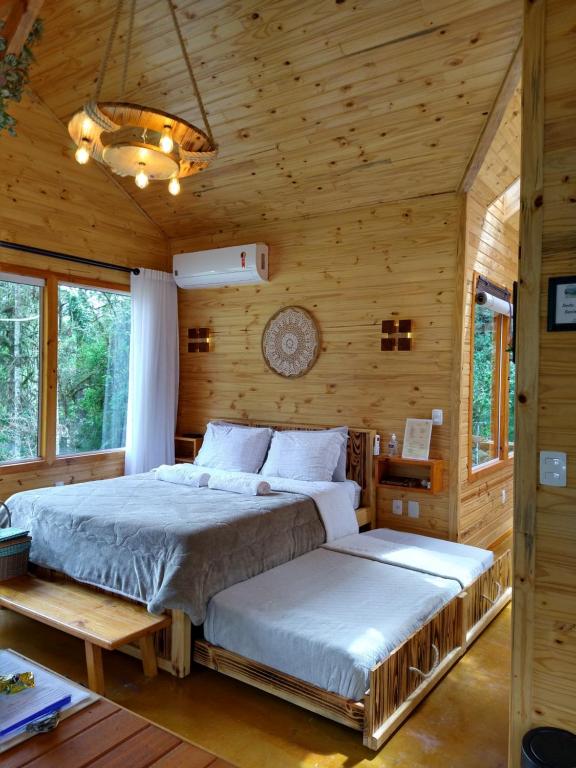 um quarto com 2 camas num chalé de madeira em Chalés Estância Cachoeira do Avencal em Urubici