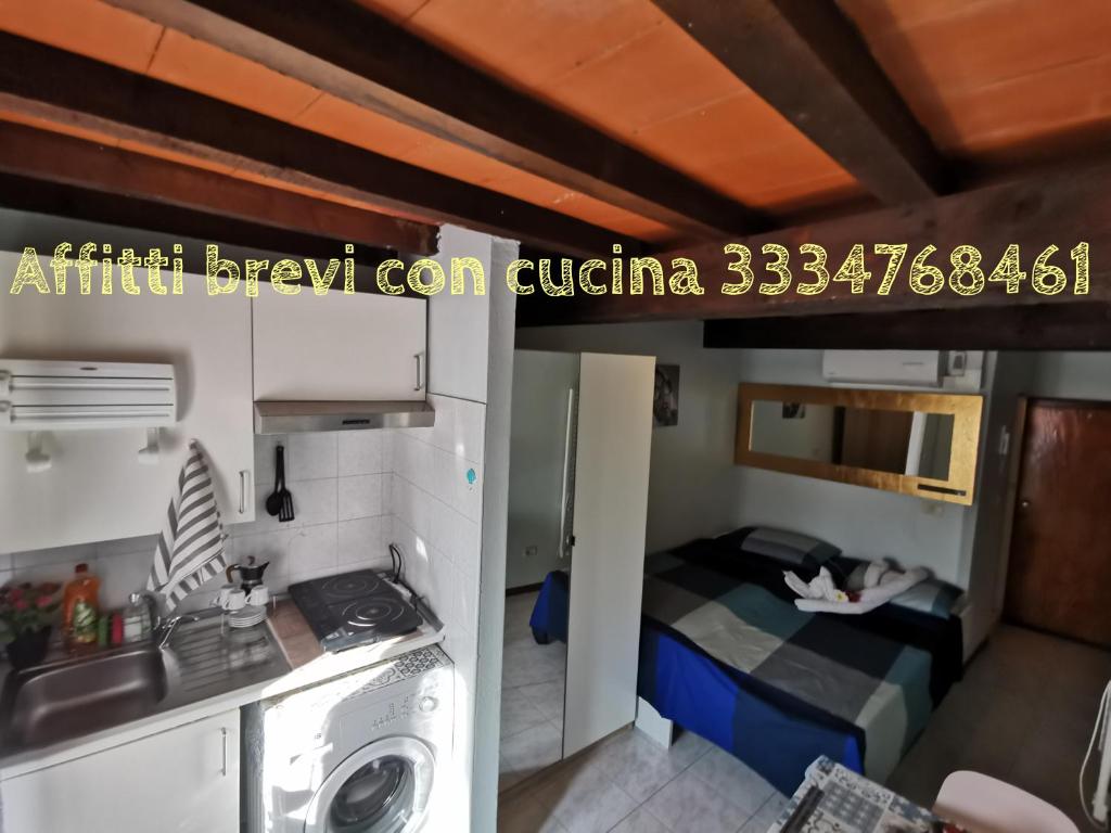 Habitación pequeña con cama y lavadora. en Piccola Stella, en Parma