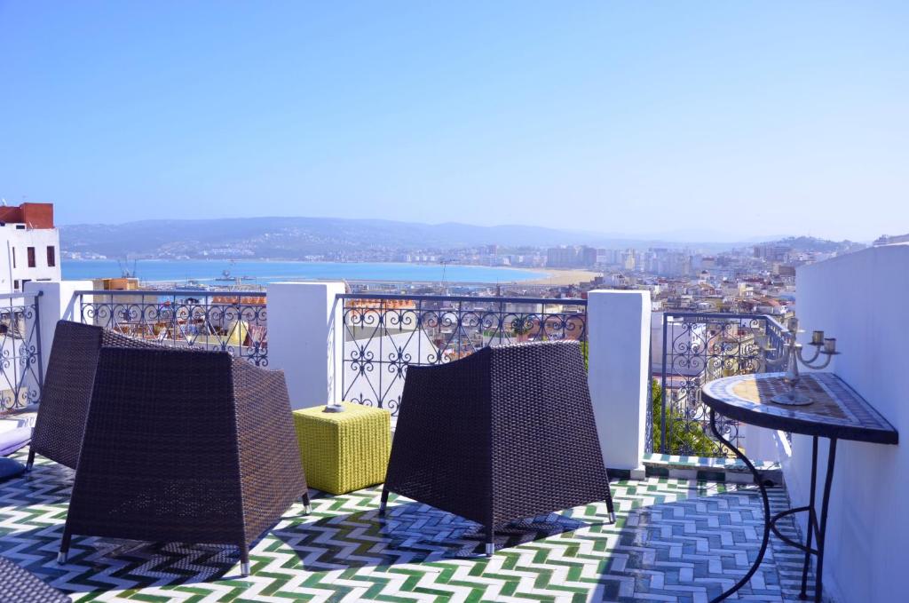 a balcony with two chairs and a table and a view at Tanger Chez Habitant in Tangier