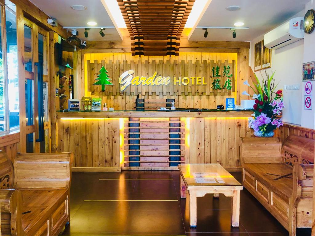 un restaurante con un bar con paredes de madera y una mesa en Semerah Garden Hotel, en Pontian Kecil