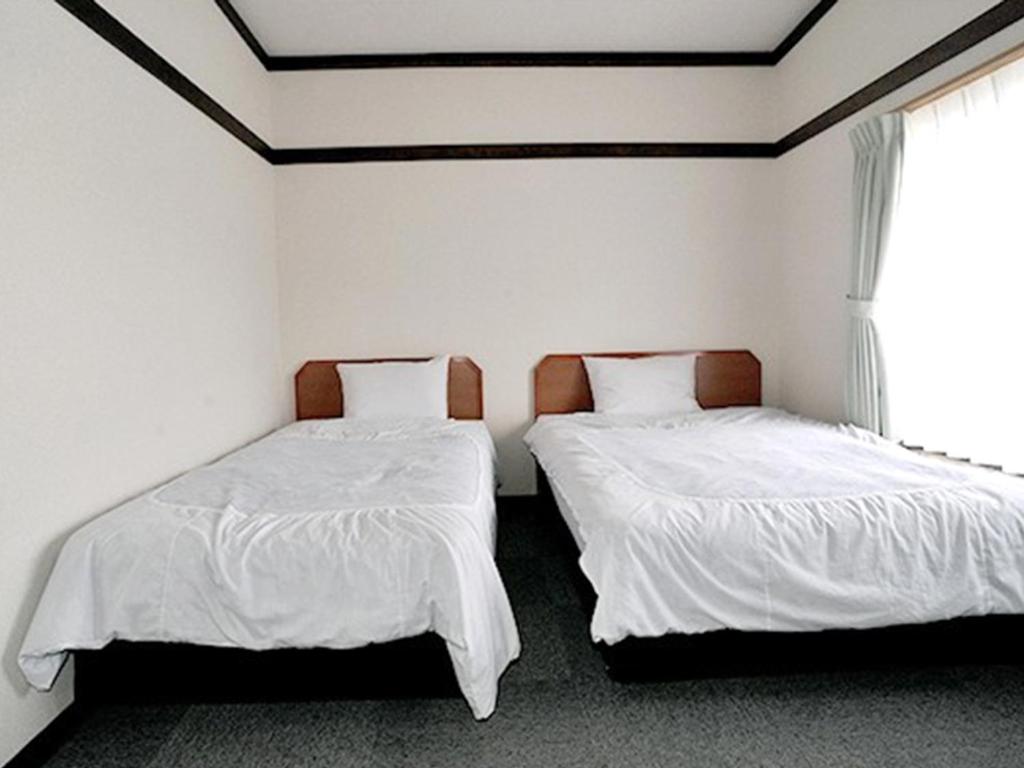 Postel nebo postele na pokoji v ubytování Ryokan Seifuso
