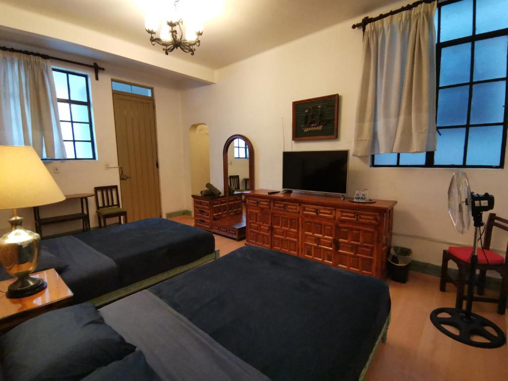 a bedroom with two beds and a flat screen tv at Home Sweet Home in Cuernavaca