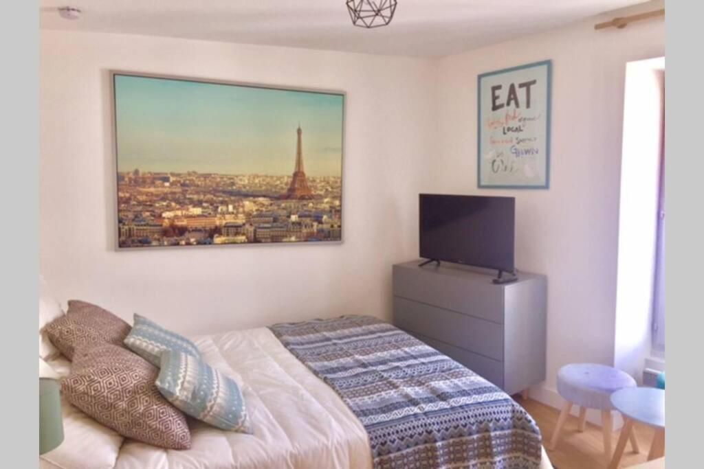 a bedroom with a bed and a picture of the eiffel tower at French typical apartment (opéra 5D) in Paris