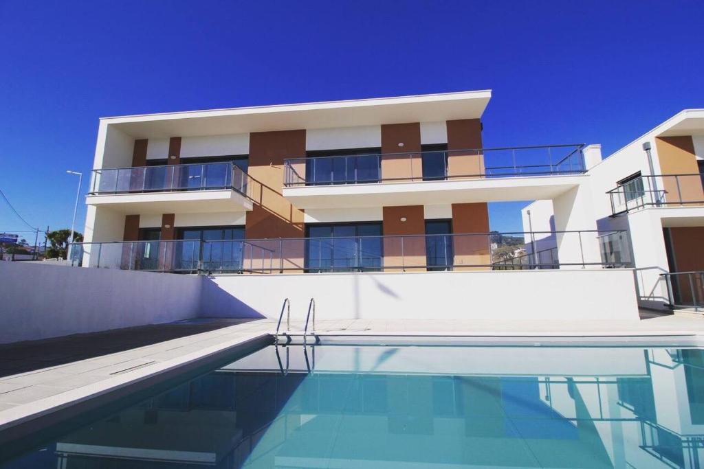 a building with a swimming pool in front of it at Bela Concha - Bela Baia 3 in Salir do Porto