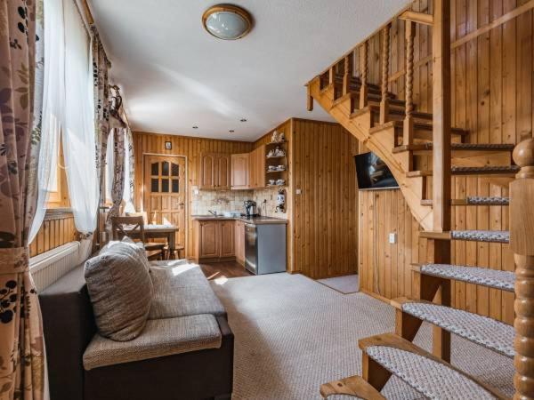 a living room with a staircase and a kitchen at Apartament u Tomka in Zakopane