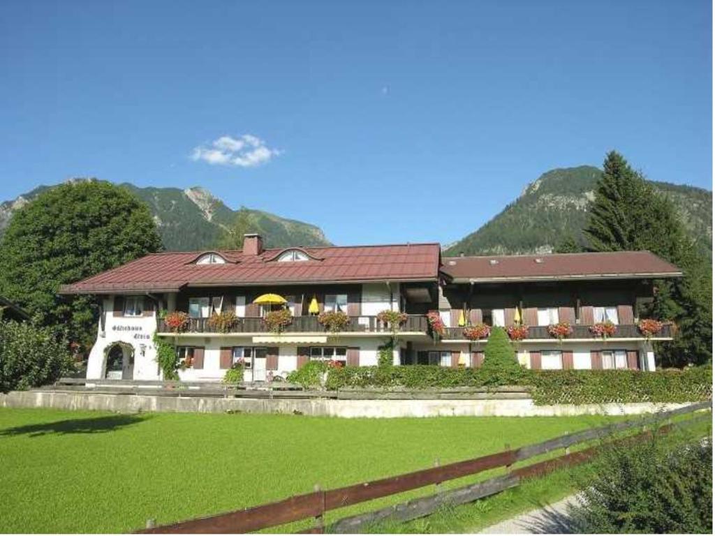 un gran edificio con un gran patio y una montaña en Gästehaus Elvia, en Oberstdorf