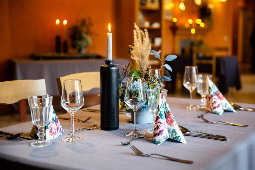 a table with a candle and wine glasses on it at Karlamuiza Country Hotel in Kārļi