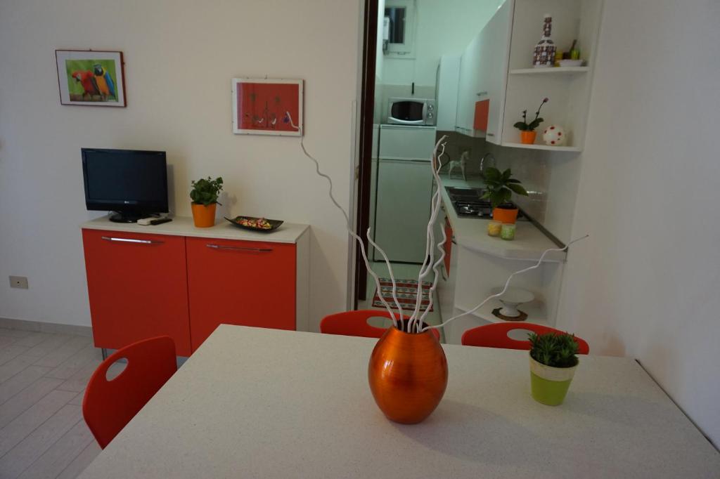 una cocina con un jarrón naranja sentado en una mesa en Residence Eva, en Lignano Sabbiadoro