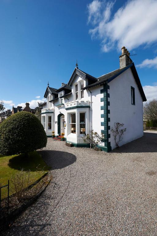 a large white house with a gravel driveway at Moyness House in Inverness