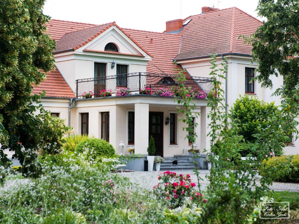 Biały dom z czerwonym dachem w obiekcie Dwór Niemierzyce w mieście Granowo