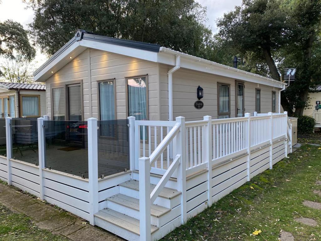 una pequeña casa blanca con una valla blanca en Sea Shore Lodge Mudeford en Christchurch