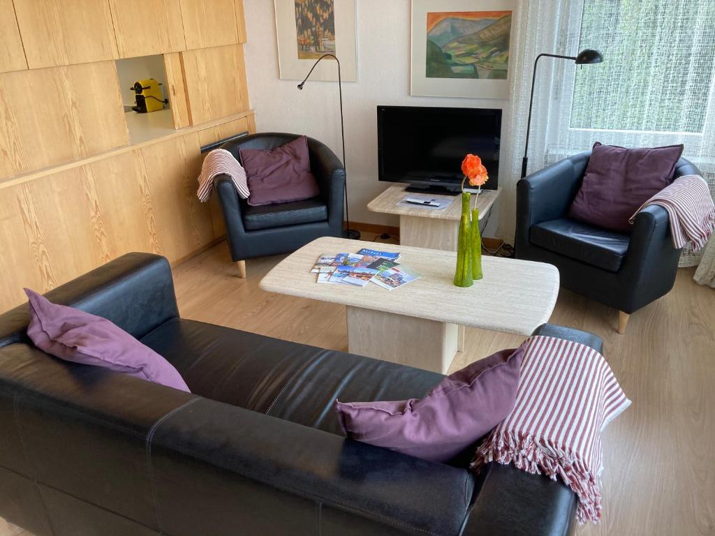 a living room with a couch and two chairs and a table at Feriensiedlung Trü 7 in Scuol