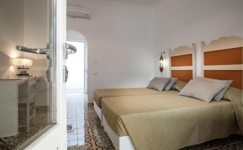 a bedroom with a large bed and a mirror at Mari del Sud Resort in Vulcano