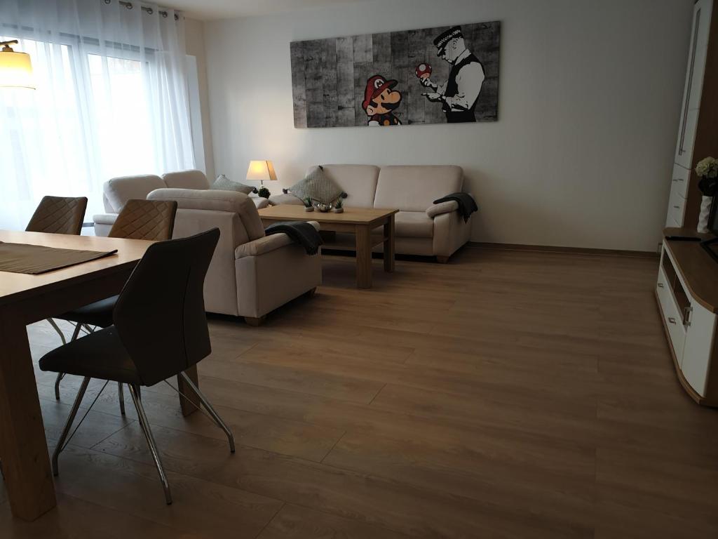 a living room with a couch and a table at BREUERS PulHEIM Appartment blau in Pulheim