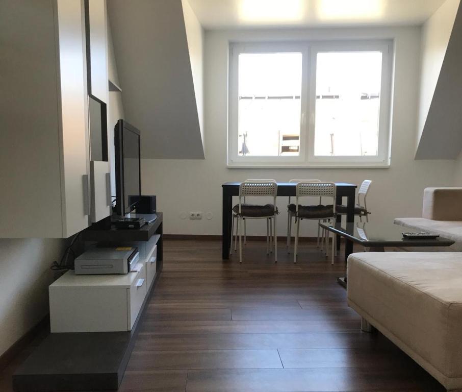 uma sala de estar com uma cama e uma mesa com cadeiras em SUNNY VIENNA by JR City Apartments em Viena