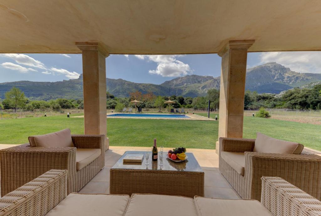 un patio con sillas y una mesa con una botella de vino en VILLA PARADÍS en Pollensa