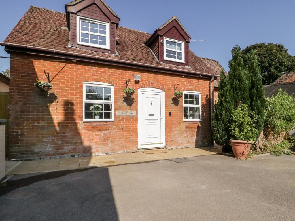 a red brick house with a white door at The Cottage in Salisbury