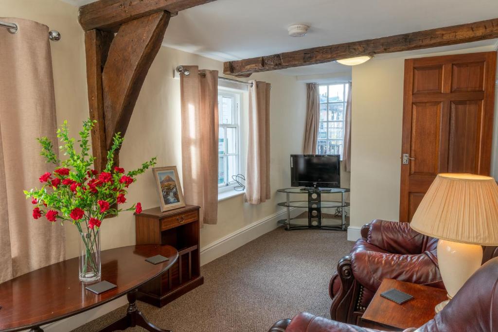 una sala de estar con un jarrón de flores sobre una mesa en Highgate View Apartment, en Kendal