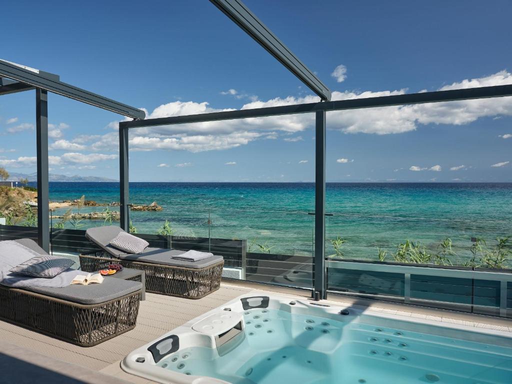 a hot tub in a room with a view of the ocean at Blue View Villa - Coastal Elegance with Swim Spa, by ZanteWize in Alikanas