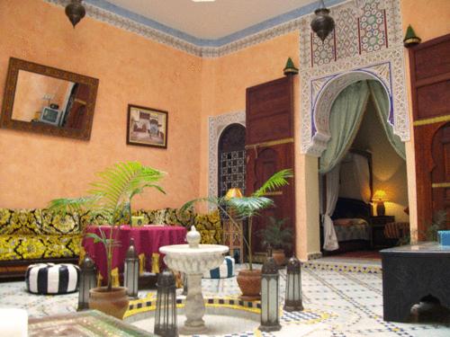 een woonkamer met een bank en een tafel bij Riad Idrissi in Meknès