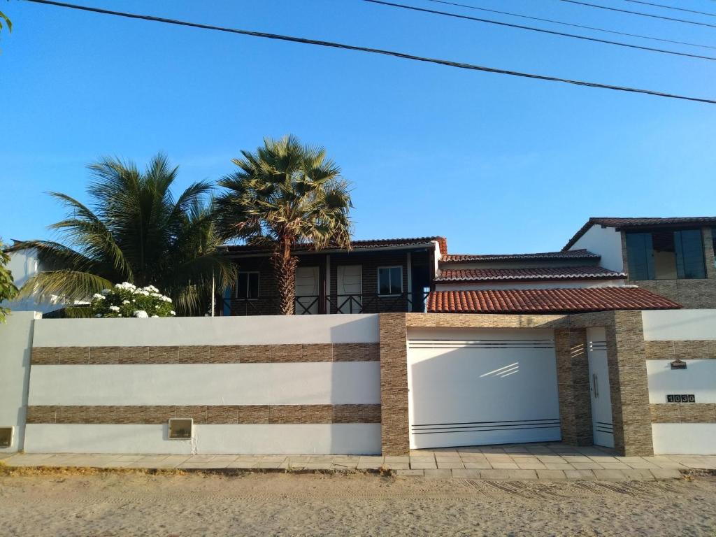 a white fence with a garage door in front of a house at Laggon Residence in Jijoca de Jericoacoara