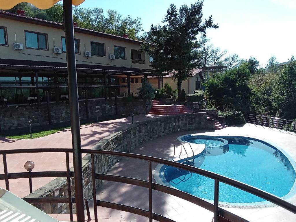 a balcony with a swimming pool and a building at Park Hotel Stratesh in Lovech