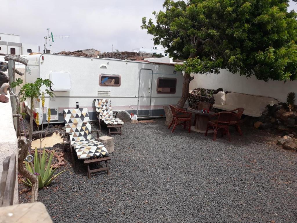 un patio con mesa y sillas y una caravana en "Lapa" Caravan Apartamento, en Tinajo