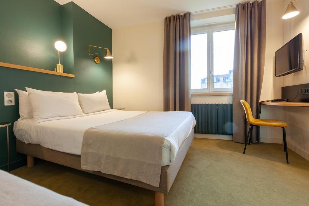 um quarto de hotel com uma cama e uma secretária em Grand Hotel de la Gare em Angers