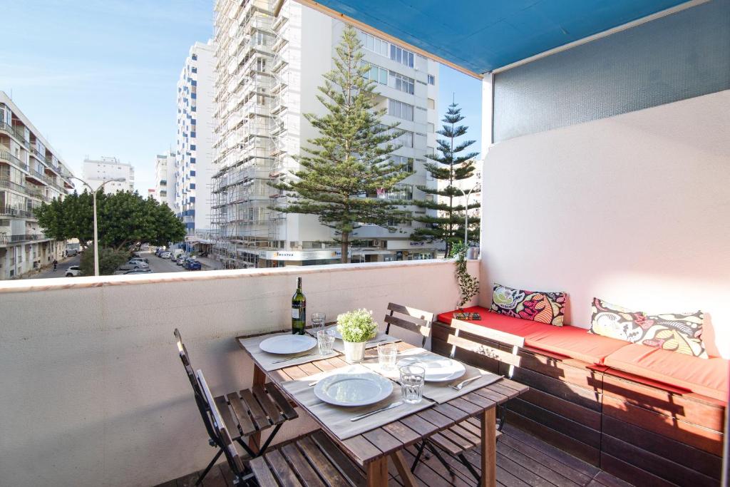 a table and chairs on a balcony with a window at Modern Apartment by the Sea in Quarteira