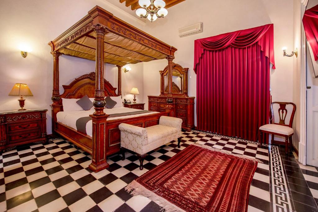sypialnia z łóżkiem z baldachimem i podłogą wyłożoną szachownicą w obiekcie Hotel Senorial w mieście Querétaro