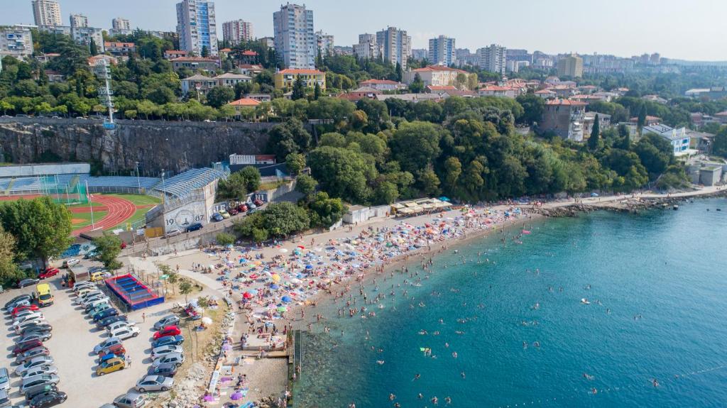 z góry widok na plażę z tłumem ludzi w obiekcie Apartments Školjka w mieście Rijeka