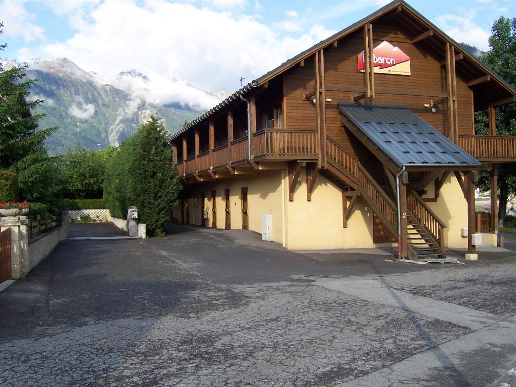 un grand bâtiment avec un toit et un balcon dans l'établissement L'Albaron, à Modane