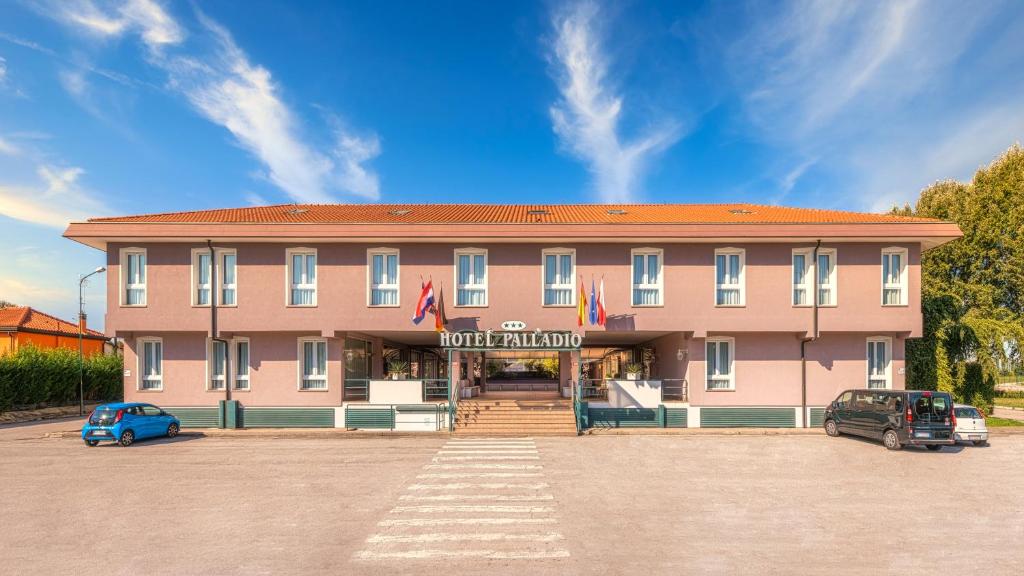 een gebouw waar een auto voor geparkeerd staat bij Hotel Palladio in Malcontenta