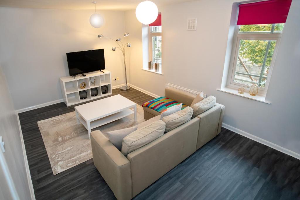 ein Wohnzimmer mit einem Sofa und einem TV in der Unterkunft Two Bedroom Duplex in Angel HIgh Street in London