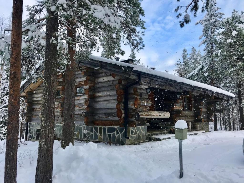 a log cabin in the snow with a parking meter at Kelogornitsa in Kittilä
