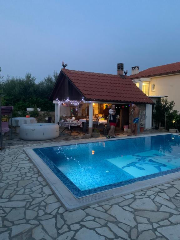 a swimming pool in a yard with a gazebo at Villa Lory Krk in Krk