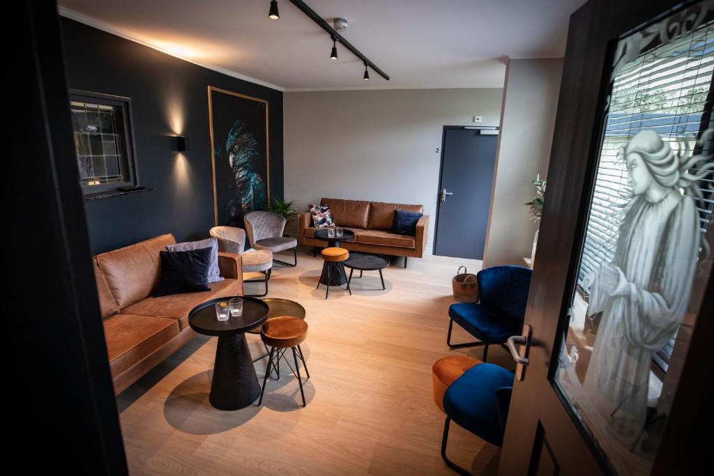 a living room with a couch and tables and chairs at OP10 Logeren in Oldenzaal