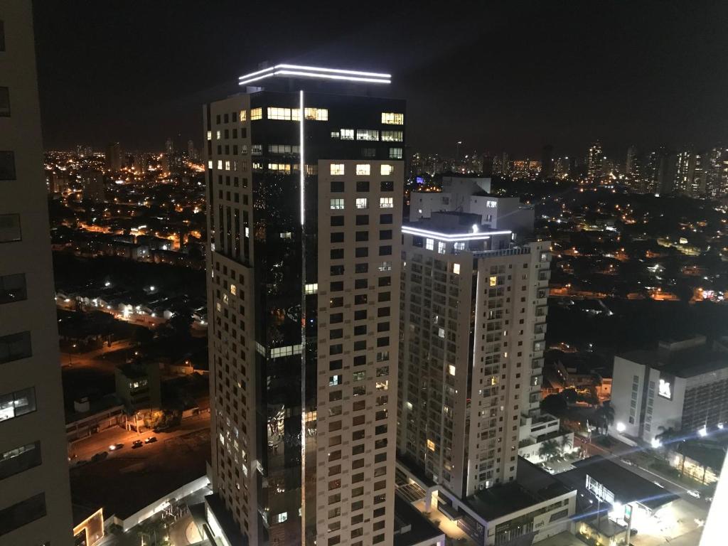 a tall building with a light on top at night at Flat no Brookfield Towers 27º Andar in Goiânia