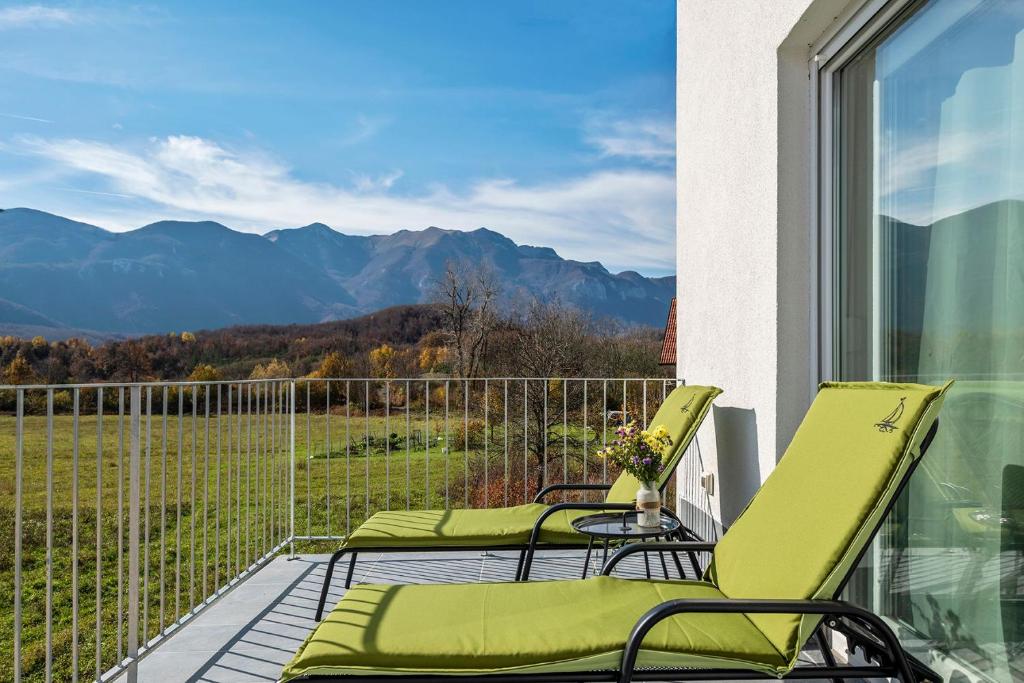 a balcony with chairs and a view of mountains at Velebit Lodge in Lovinac