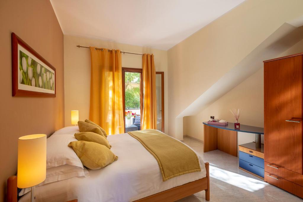 1 dormitorio con cama con almohadas y ventana en Residence Smeraldo en San Vito lo Capo