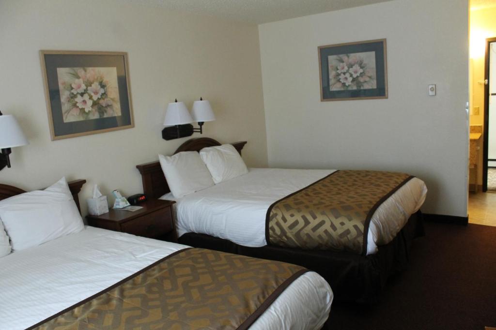 a hotel room with two beds with white sheets at Lone Tree Inn in Sidney