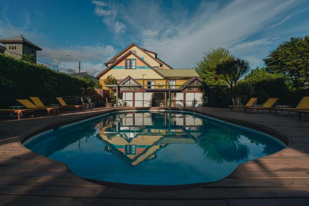 a house with a swimming pool in front of a house at Selina Plaza Pucón in Pucón