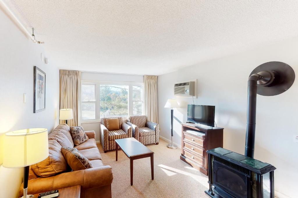 a living room with a couch and a fireplace at Mountainside Resort III in Stowe