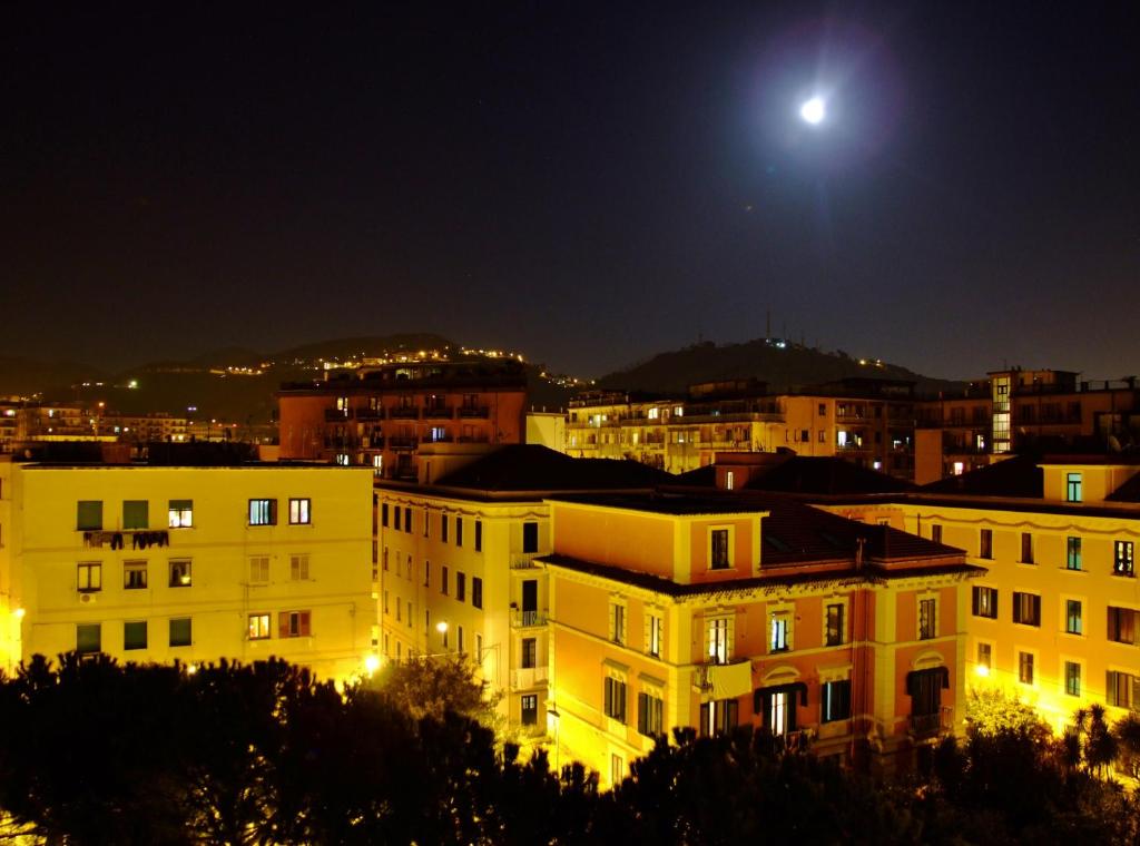 a view of a city at night with the moon at L'Una di Notte in Salerno