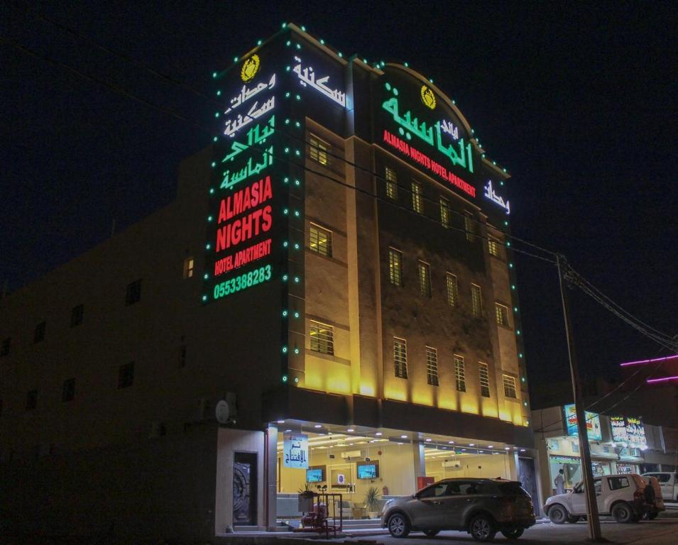 a building with neon signs on the side of it at ليالي ألماسية للشقق المخدومة Layali Almasiah serviced apartment in Al Muzāḩimīyah