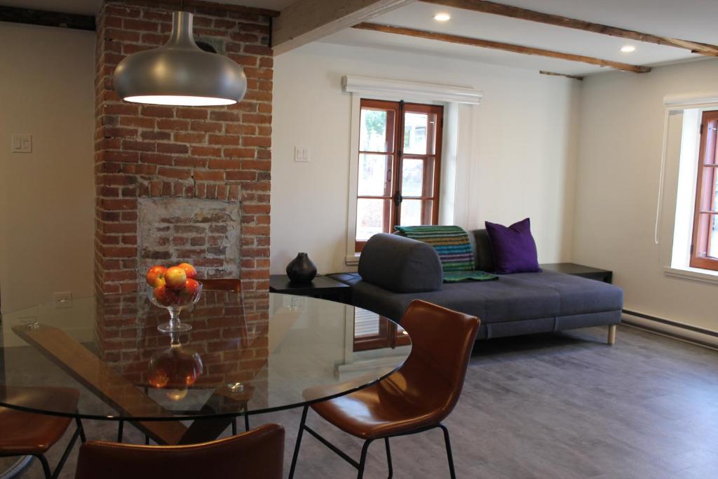 een woonkamer met een bank en een glazen tafel bij Appartements Gite Kezako in Lévis