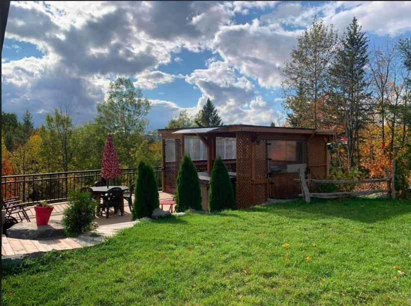 a small cabin in the middle of a yard at La Spacieuse Riverstone in Saint Pierre de Broughton