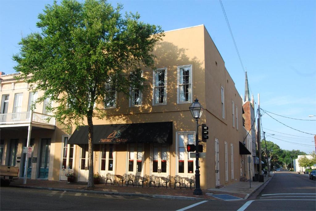 a building on the corner of a street with a tree at Natchez Manor Bed & Breakfast in Natchez